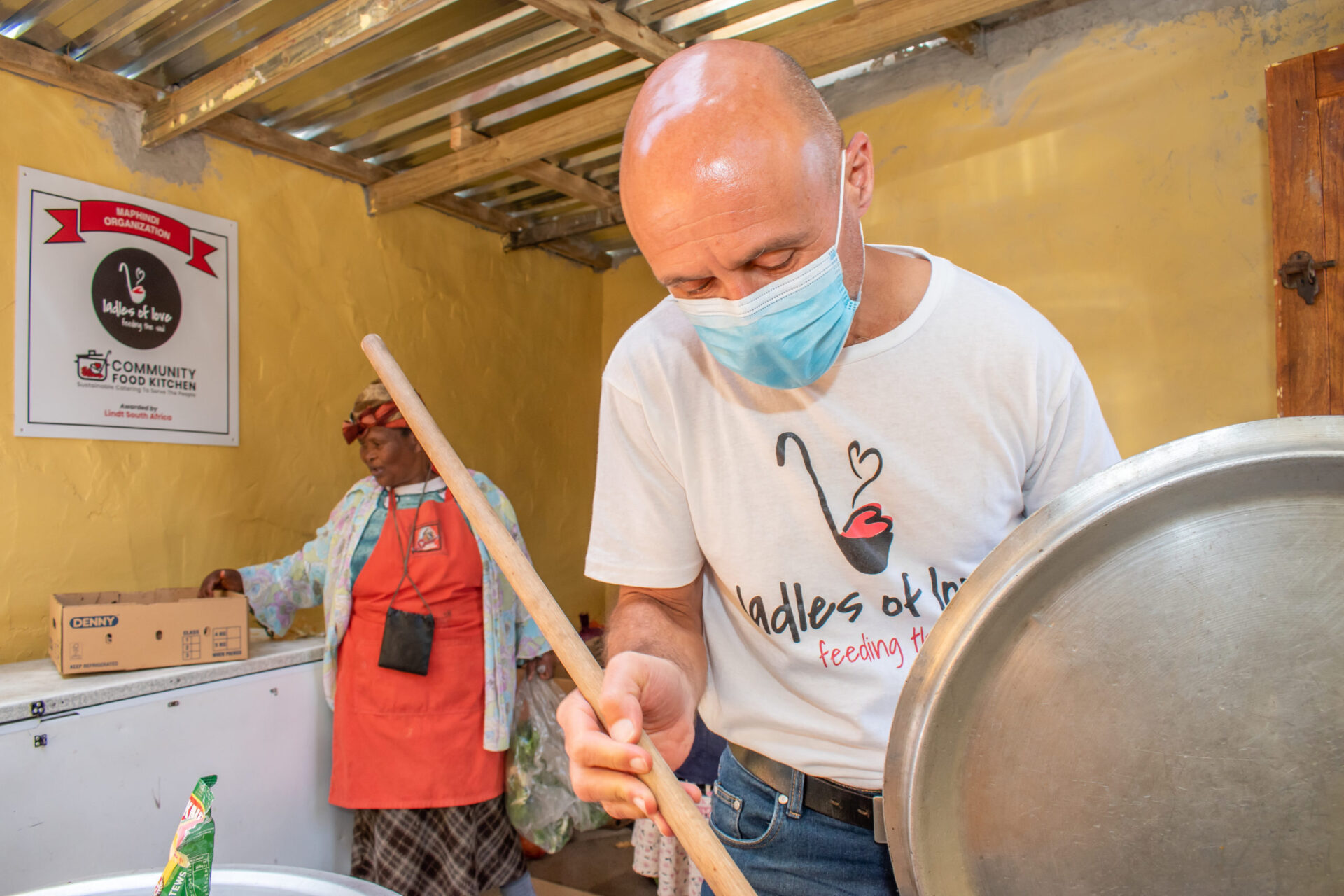 Founder Danny Diliberto stirs a pot of soup with Mama Victoria in the background