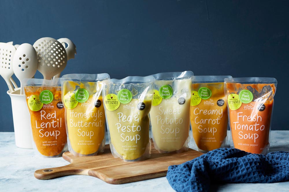 The six types of Pesto Princess soup that are sold to raise funds for Ladles of Love, lined up in a row on a chopping board